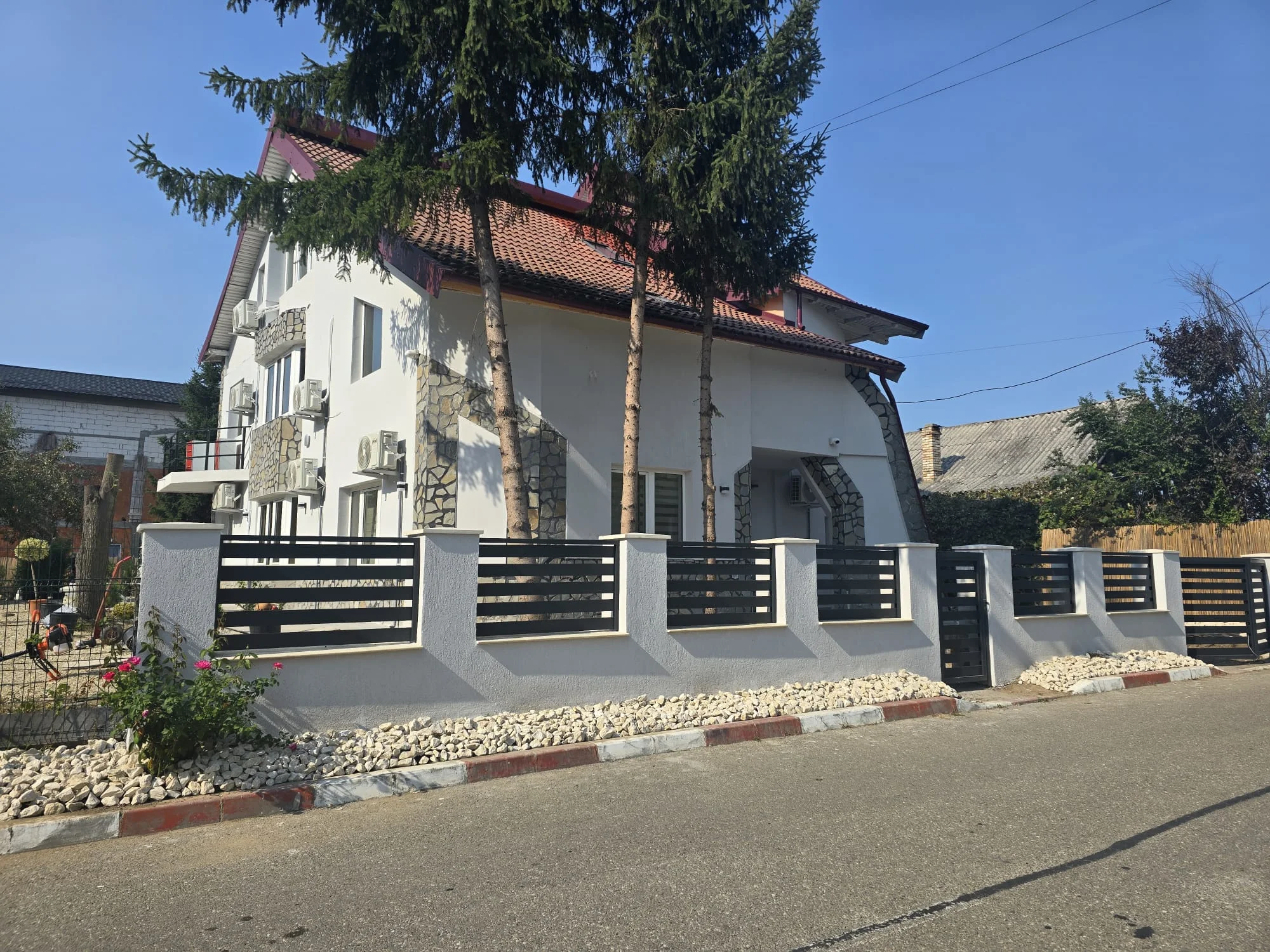 Clădirea clinicii văzută de pe stradă, cu gardul și intrarea