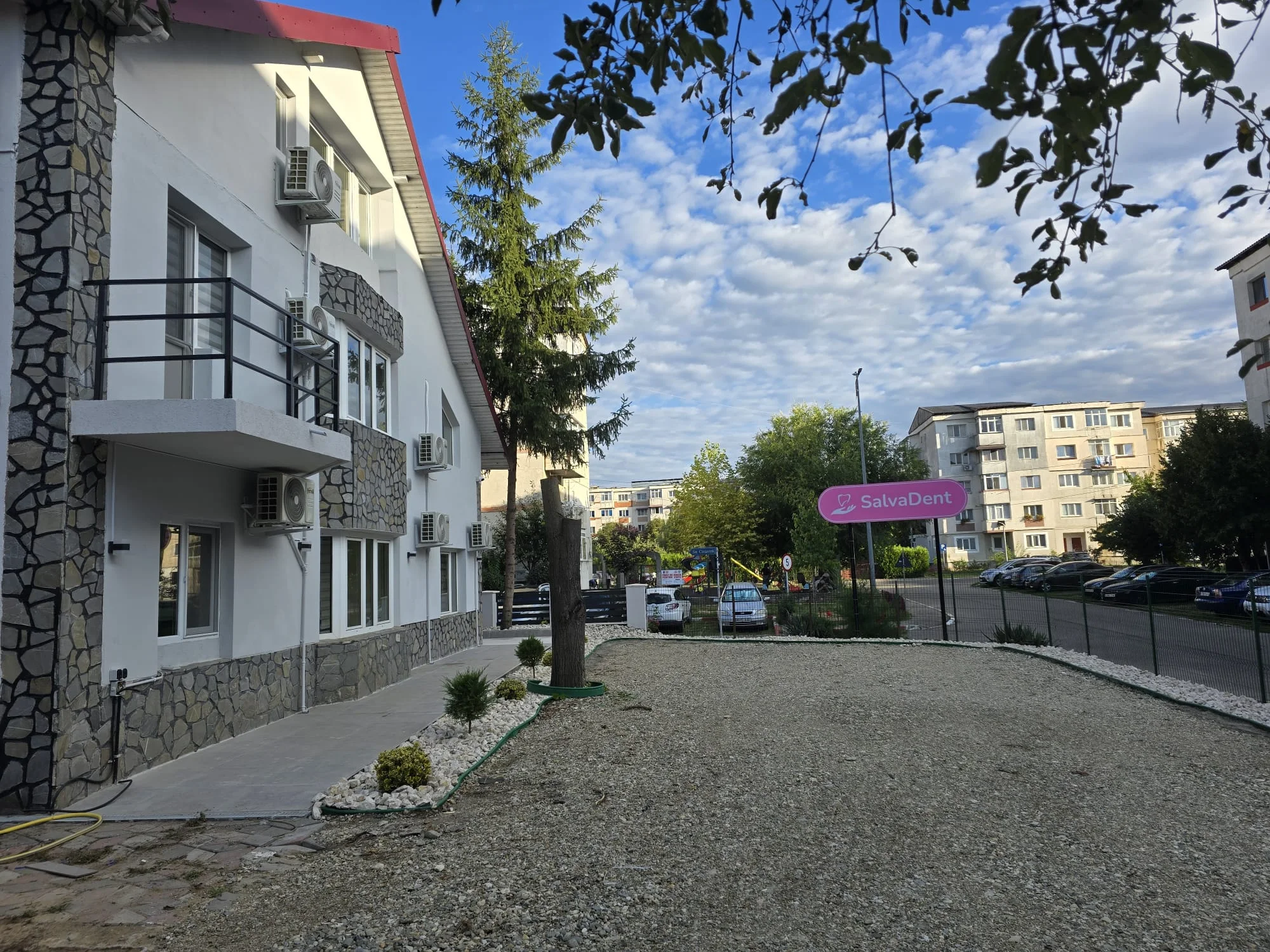 Aleea de acces și curtea clinicii, cu blocurile din apropiere